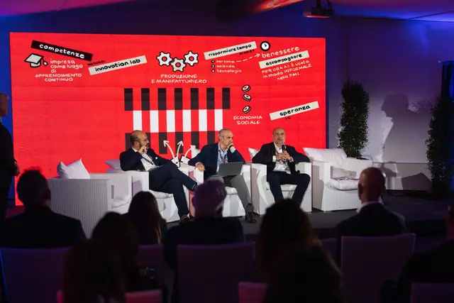 La restituzione dei tavoli tematici sul palco, davanti allo schermo rosso